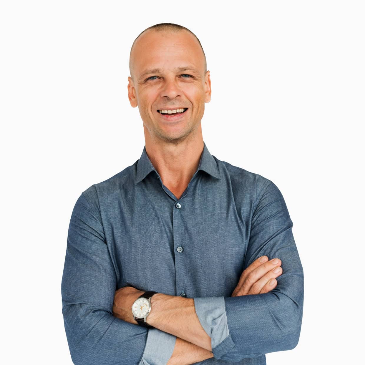 Smiling man wearing a blue shirt with arms crossed against a plain background.
