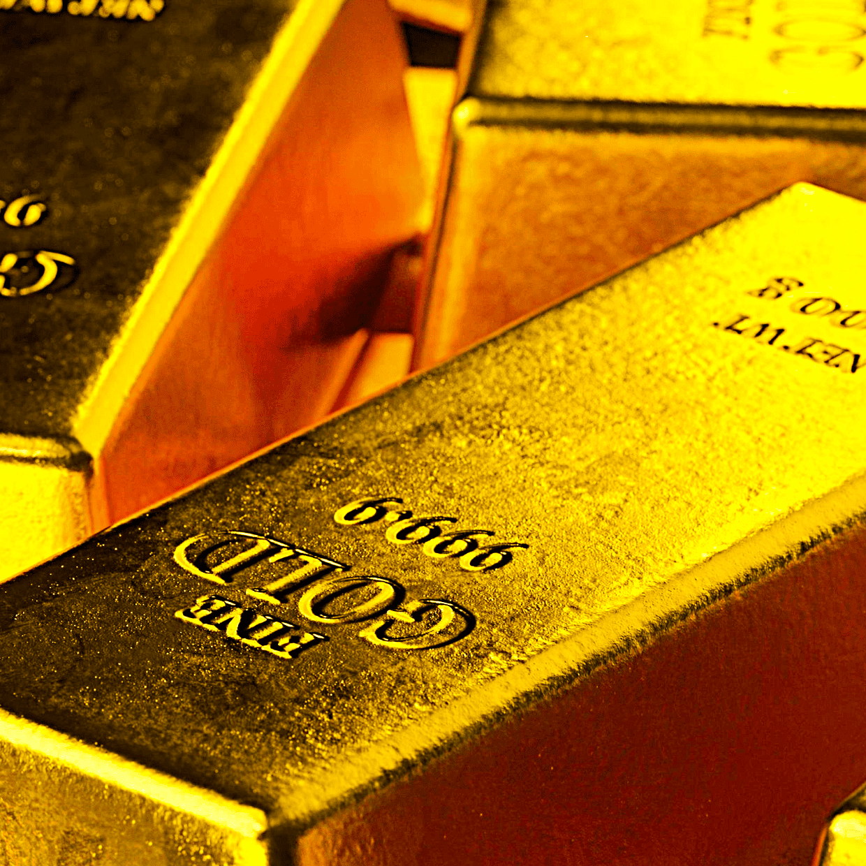 Close-up of stacked gold bullion bars with markings showing weight and purity.