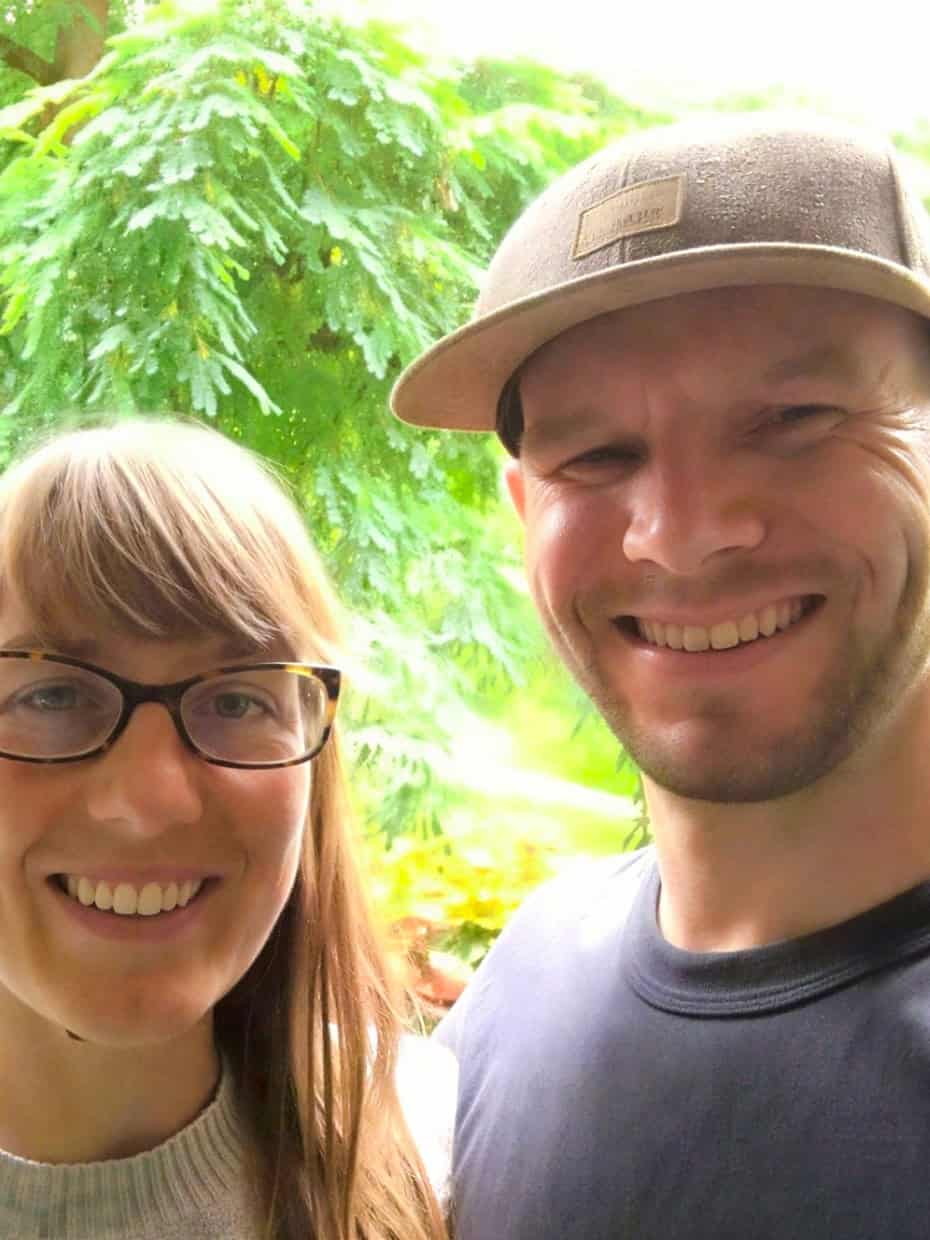 Steve and Tanya Bownds smiling together outdoors with trees and greenery in the background.